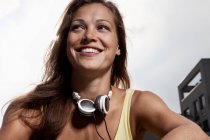 Mujer con auriculares alrededor del cuello - foto de stock