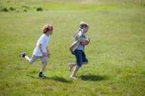 Crianças perseguindo uns aos outros ao ar livre — Fotografia de Stock