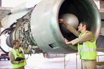 Trabajadores aeronáuticos revisando avión - foto de stock