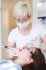Стоматолог працює над зубами пацієнтів — стокове фото