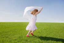 Девушка бегает с белым шарфом — стоковое фото