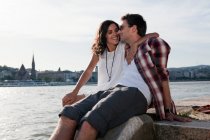 Couple hugging by city river — Stock Photo