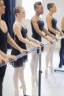 Ballet dancers practicing at barre — Stock Photo
