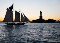Лодка мимо Статуи Свободы — стоковое фото