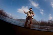 Hombre pescando en el lago - foto de stock