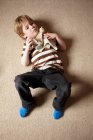 Garçon pose sur le tapis et tenant jouet — Photo de stock