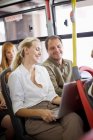 Улыбающиеся люди сидят в автобусе — стоковое фото