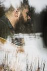 Uomo barbuto che suona la chitarra accanto alla finestra — Foto stock
