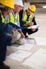 Workers reading blueprints on site — Stock Photo