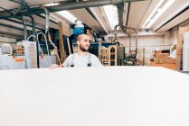 Tischler mit großem Holzblech in Werkstatt — Stockfoto