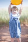 Toddler girl with ball on dirt road — Stock Photo