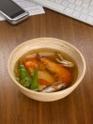 Bowl of soup on desk — Stock Photo