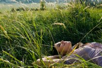 Молода жінка лежить у траві — стокове фото