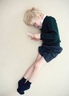 Rapaz deitado no chão a brincar com a Nina — Fotografia de Stock