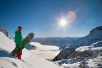 Сноубордист смотрит с вершины горы — стоковое фото