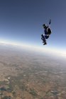Freifliegender Fallschirmspringer bei blauem Himmel — Stockfoto