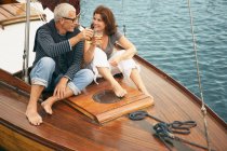 Пара средних лет пьет на лодке — стоковое фото