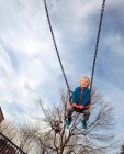 Garçon jouer dans swing au parc — Photo de stock
