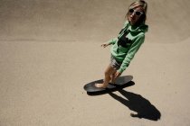 Donna in sella longboard su cemento — Foto stock