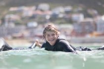 Jeune garçon pagayant avec planche de surf, mise au point sélective — Photo de stock
