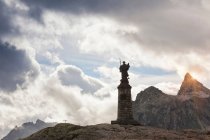 Прикрашена статуя на скелястому гірському масиві з хмарним небом — стокове фото