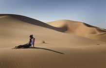 Young woman practicing yoga on a sand dune in the desert, Abu Dhabi, Abu Dhabi Emirate, UAE — Stock Photo