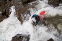 Homem canoagem sobre cachoeira rochosa — Fotografia de Stock