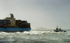 Container ship run aground with tugs rescuing — Stock Photo
