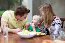 Famiglia che mangia un pasto insieme a casa — Foto stock