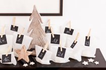 Numbered bags with wooden decorations on desk — Stock Photo