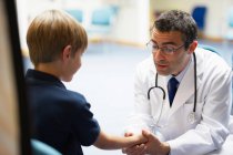 Médecin examinant jeune garçon — Photo de stock