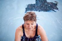 Женщина плескается в бассейне — стоковое фото
