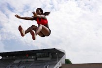 Atleta no ar durante salto em distância — Fotografia de Stock