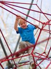 Junge klettert auf Spielplatz — Stockfoto