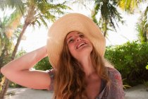Frau mit Sonnenhut in tropischem Resort — Stockfoto