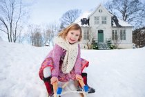 Skandinavisches Mädchen sitzt auf einem Schlitten — Stockfoto