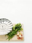 Vegetables and potatoes with colander on cutting board — Stock Photo