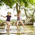 Chicas sonrientes jugando en el lago, enfoque selectivo - foto de stock