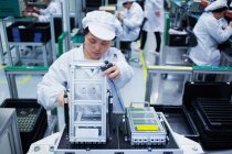 Trabajador en la fábrica de fabricación de piezas pequeñas en China - foto de stock