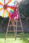 Chica poniendo decoración en el jardín en la fiesta - foto de stock