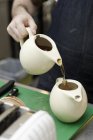 Бариста наливает чай в чайник — стоковое фото