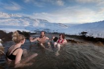 Friends relaxing in glacial hot spring — Stock Photo