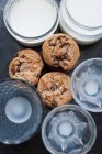 Печенье со стаканами и банками молока — стоковое фото