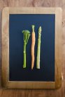 Carrot, broccoli and asparagus on blackboard — Stock Photo