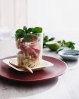 Proscuitto in glass with herbs — Stock Photo