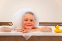 Boy covered in bubbles in bathtub — Stock Photo