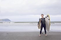 Retrato de hombre con tablas de surf en la playa - foto de stock