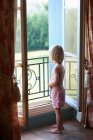 Хлопчик дивиться у вікно спальні — стокове фото