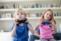 Crianças jogando jogos de vídeo juntos, foco em primeiro plano — Fotografia de Stock