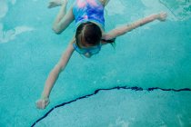 Дівчина плаває в басейні, вид зверху — стокове фото